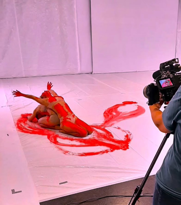 Musikvideodreh: Zwei Frauen am Boden in kunstvollen Posen mit roter Farbe